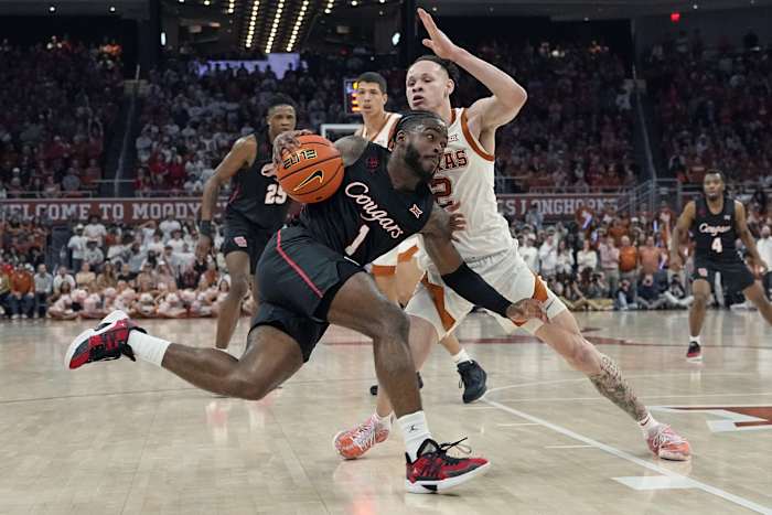 Houston Cougars guard Jamal Shead (1) drives to the basket while defended by Texas Longhorns guard Chendall Weaver (2) during the second half at Moody Center.